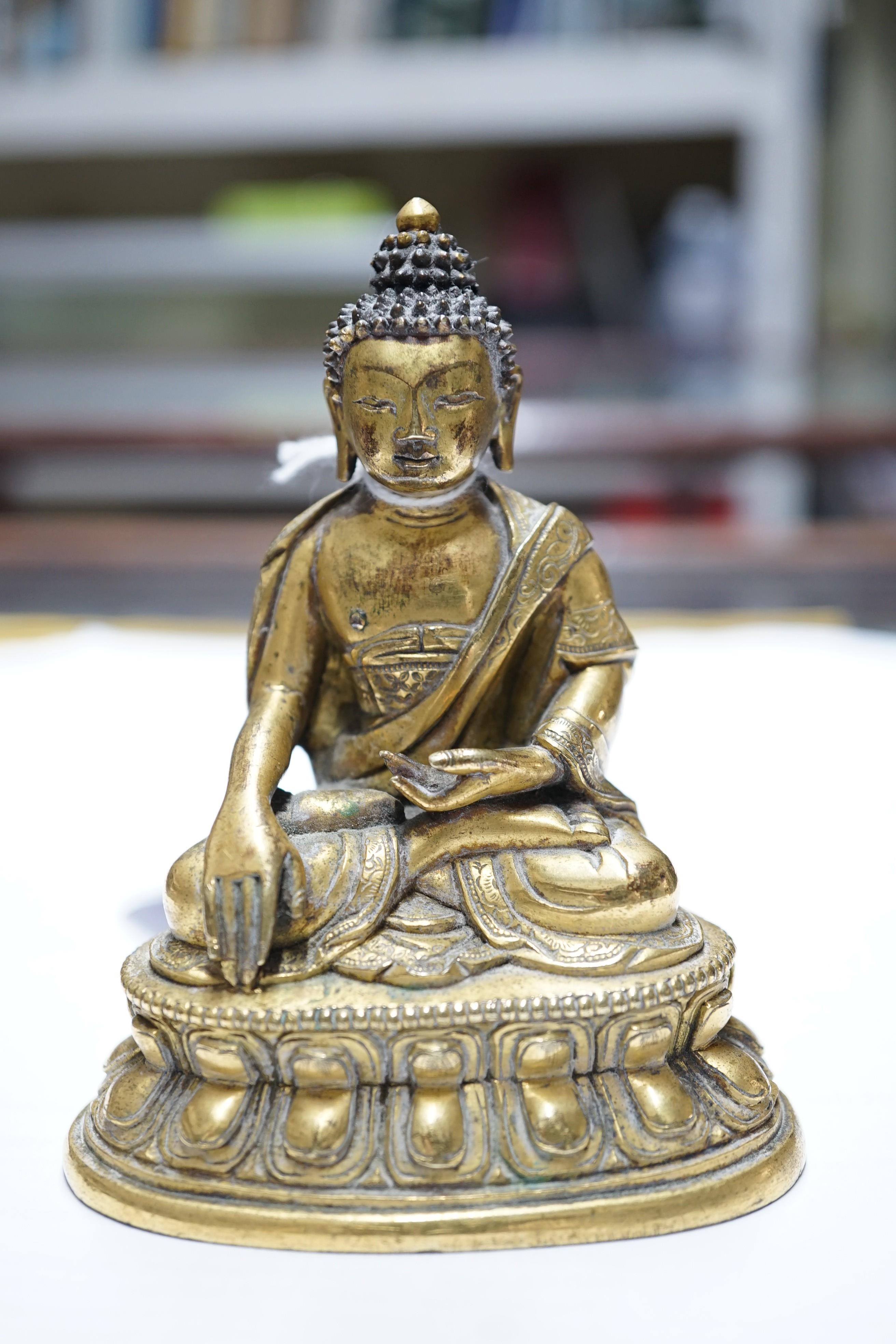A small Tibetan gilt bronze seated figure of Buddha Shakyamuni, 18th century, 9.5cm high, lacking bowl in left hand